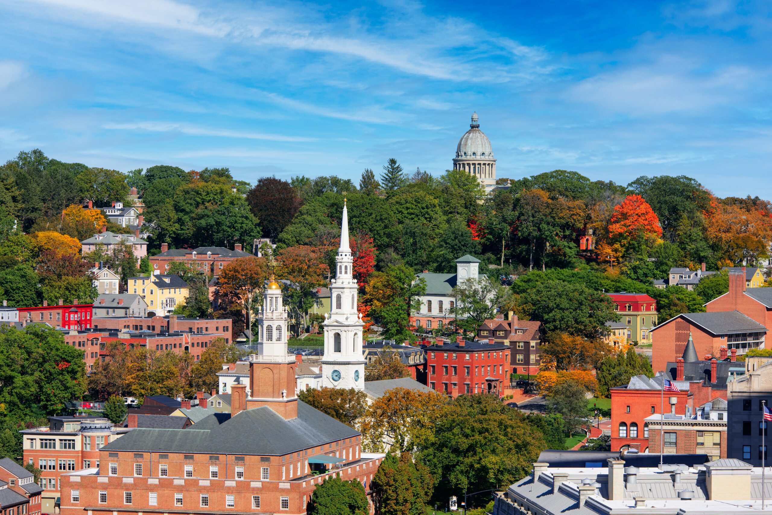 View of New England town landscape with brick buildings, a clock tower, and fall foilage